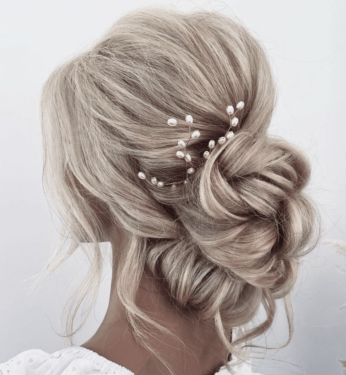 low textured bun with flower accessories hairstyle